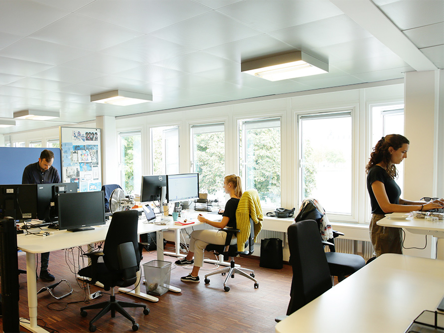 Foto des Debitoor-Büros, in dem Mitarbeiter an ihren Schreibtischen arbeiten